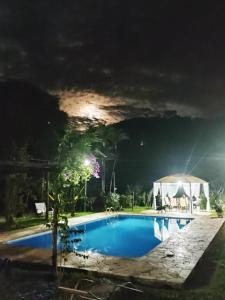 a swimming pool at night with a tent at Hotel Fazenda Polyanna in Mariana +65 photos