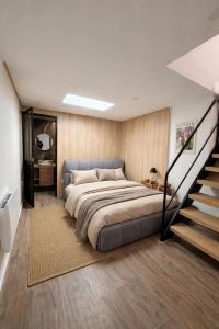 a bedroom with a large bed and a staircase at Appartement et spa in Douai