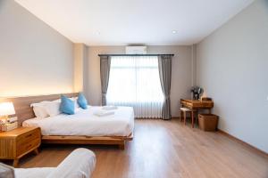 a bedroom with a bed with blue pillows and a window at The Peak Hill Pool Villa in Ban Wa Kachieo