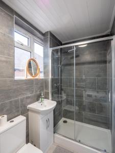 a bathroom with a shower and a toilet and a sink at Spacious 2-Bedroom Flat in Worcester Park