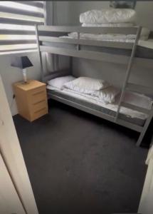 a room with two bunk beds and a night stand at 2 Bedroom Chalet Close to Beach in Hemsby