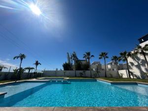 a swimming pool in front of a house with palm trees at Baja Ocean View 3 BR Panoramic Terrace & Private Jacuzzi 8pp in Rosarito