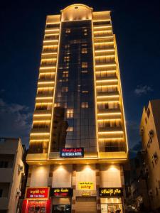 a tall building with lights on top of it at فندق الرسالة الفندقية ذاخر توصيل مجاني من والى الحرم Al-Risala Hotel Zakhar Free delivery to and from the Haram in An Naqāʼ