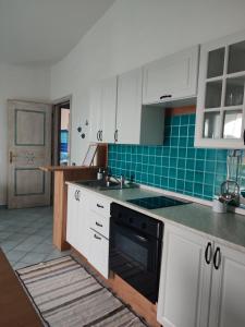 a kitchen with white cabinets and a sink and an oven at Villetta bifamiliare con vista mare "Poggio Tavolara" in Porto San Paolo
