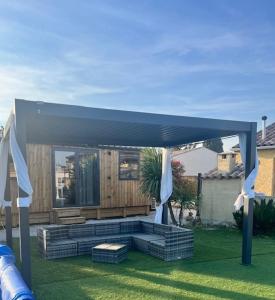 a gazebo with a bench in a yard at La Tiny de la chicorée in Paulhan