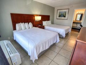 a hotel room with two beds and a tv at Clearwater Beach Hotel in Clearwater Beach