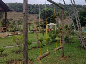 an empty swing set in a park with trees at Hotel Fazenda Polyanna in Mariana