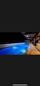 a swimming pool with blue lighting in a building at Jbs place at Jtower Residences in Mandaue City