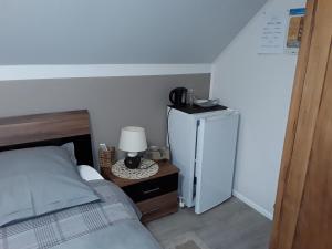 a bedroom with a bed and a small refrigerator at Chambres d'Hôtes Arnold in Dambach-la-Ville