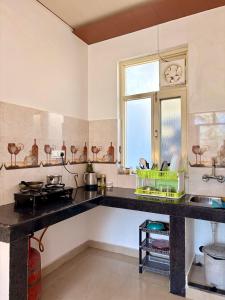 a kitchen with a counter top and a window at Brekora X RajStays in McLeod Ganj