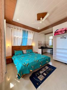 a bedroom with a bed with a blue comforter at Brekora X RajStays in McLeod Ganj