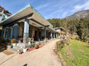a house on a hill with a mountain in the background at Brekora X RajStays in McLeod Ganj +1 photo