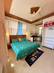 a bedroom with a bed with a green comforter at Brekora X RajStays in McLeod Ganj