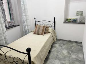 a bedroom with a black bed with two pillows at Maridea - Il Balcone sulla Storia in Ponza +7 photos