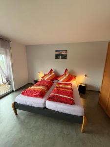 a bedroom with a bed with red and yellow pillows at Petryhof in Mörsdorf