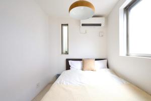 a small bedroom with a bed and a window at 東京Dong house in Wada