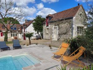 a house with a swimming pool and two lounge chairs at Gites au fil des châteaux de la Loire in Saint-Georges-sur-Cher