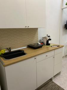 a kitchen counter with white cabinets and a sink at Little house in Vasto