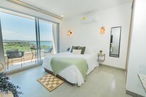 a white bedroom with a bed and a balcony at Elemnt Rentals in Santa Marta +172 photos