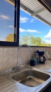 a sink in a kitchen with a window at Matapalo Hosting in Savegre