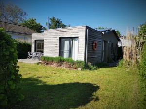 a small wooden cabin in a yard with a lawn at BlueNote Loissin in Loissin +21 photos