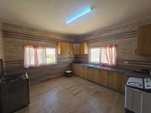 a kitchen with wooden cabinets and a counter top at بيت اطلالة الوادي in Ajloun +18 photos