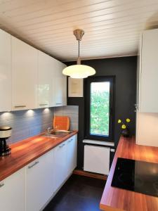 a kitchen with white cabinets and a sink and a window at BlueNote Loissin in Loissin