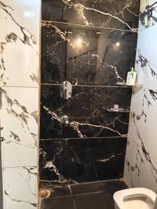 ein Badezimmer mit einer schwarz-weißen Marmordusche in der Unterkunft Hotel Aero View in Dabok