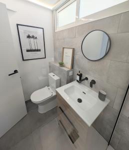 a bathroom with a sink and a toilet and a mirror at Loft with Private Pool in Alzira in Alzira +13 photos