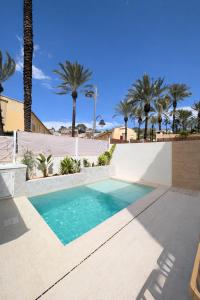 a swimming pool with palm trees in the background at Loft with Private Pool in Alzira in Alzira