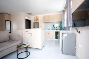 a kitchen and living room with a couch and a refrigerator at The Elite havens in Nairobi