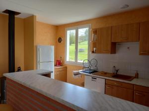 a kitchen with a white refrigerator and a window at Le Chalet de Pratviel - proche Albi in Puygouzon-et-Montsalvy