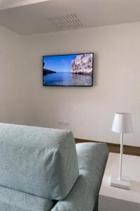 a living room with a couch and a tv on the wall at AQUAGARDEN Short Lets in Polignano a Mare