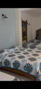 a bedroom with two beds with blue and white sheets at Mega Suite en Hotel Cosmos in Tamasopo