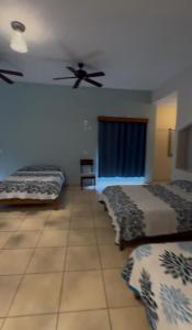 a bedroom with two beds and a ceiling fan at Mega Suite en Hotel Cosmos in Tamasopo +3 photos