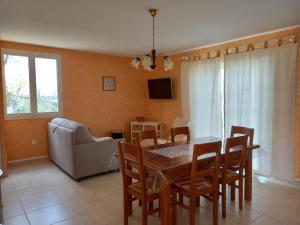 a dining room with a table and chairs and a couch at Le Chalet de Pratviel - proche Albi in Puygouzon-et-Montsalvy