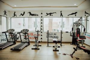 a gym with several treadmills and machines in a room at Olive apartment in Maiyegun