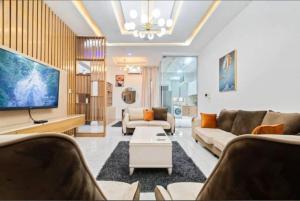 a living room with two couches and a tv at Olive apartment in Maiyegun