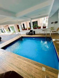 a large blue swimming pool in a building at Olive apartment in Maiyegun