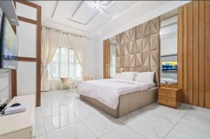 a bedroom with a large bed and a television at Olive apartment in Maiyegun