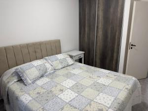 a bed with a quilt and pillows in a bedroom at San Vicente in Olavarría