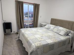 a bedroom with a bed and a window at San Vicente in Olavarría