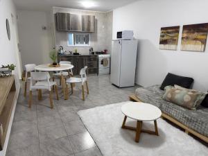 a living room with a couch and a table and a kitchen at San Vicente in Olavarría