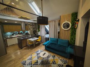 a living room with a blue couch and a kitchen at Celia Center Celje Apartment in Celje +7 photos