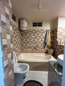 a bathroom with a tub and a toilet and a sink at Arabella Homestay in Shillong +36 photos
