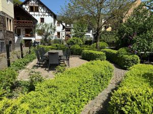 a garden with a table and chairs and bushes at Schöne Aussicht in Ediger-Eller