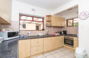 a kitchen with wooden cabinets and a white microwave at Sunset Nest in Meadowridge +6 photos