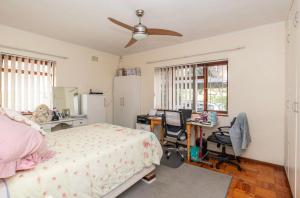 a bedroom with a bed and a desk and chairs at Sunset Nest in Meadowridge
