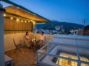 a man and woman sitting at a table on a balcony at Dar cheikh in Fez