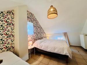 a bedroom with a bed and a table and a lamp at Gîte La Clef des Champs in Libin